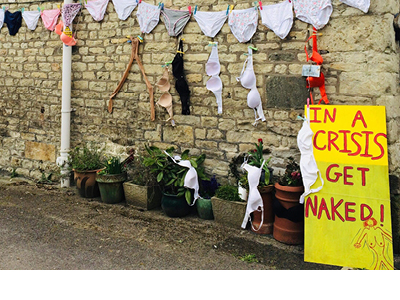 A display of a string of underwear and a funny sign saying "In a crisis get naked"
