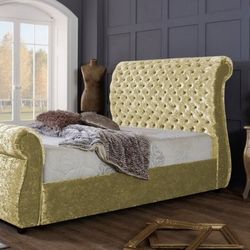 statement velvet upholstered roll top sleigh bed in gold velvet with tall back and button tufted chesterfield style button details to headboard