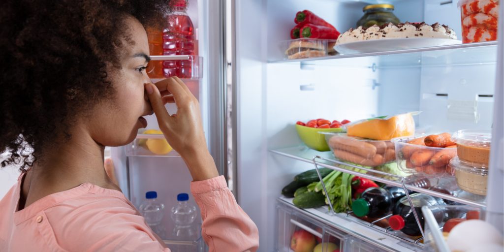 Person opening fridge door to a bad smell. Tackle bad smells to to prepare your home for sale