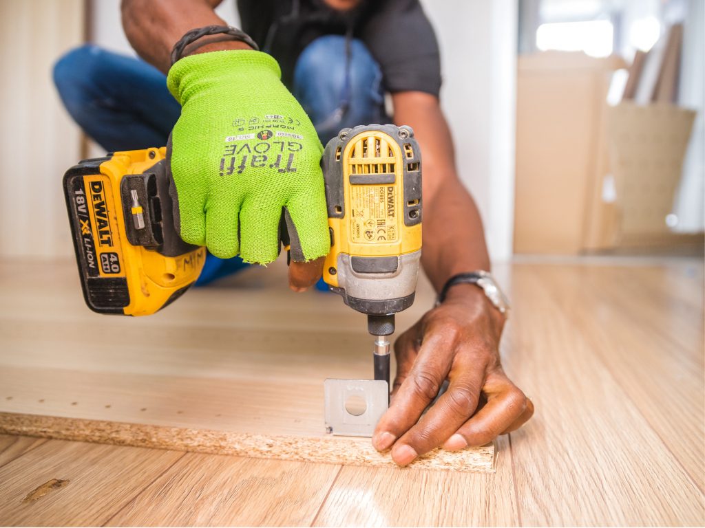 Someone using a drill to fix a piece of furniture