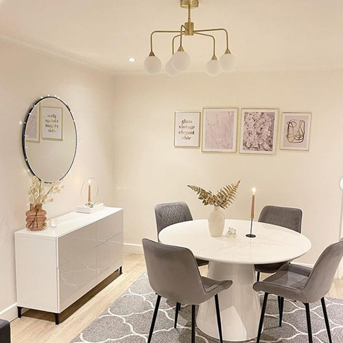 modern scandi dining room with round table and 4 grey velvet chairs