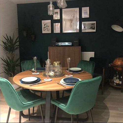 round wooden table with black legs and green velvet chairs with black legs. Would create a lovely Scandinavian dining room look