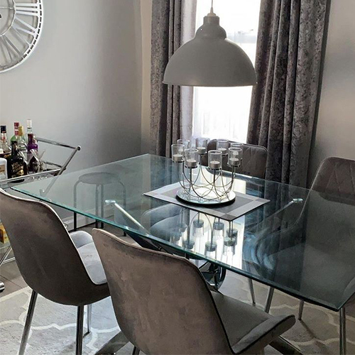 customer photo showing glass and chrome dining table with 4 Pesaro dining chairs on the Toscana rug - trellis pattern in cream and grey.