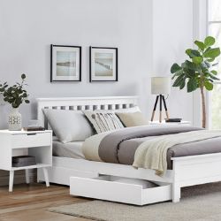 white pine bed with drawers underneath for storage, in white room with white wooden bedside tables. Scandi minimalist style