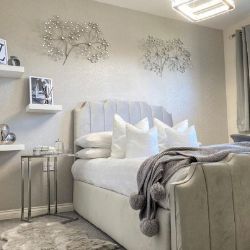 modern and luxurious child's bedroom with grey velvet bed, chrome bedside table and 3 floating shelves to right of bed