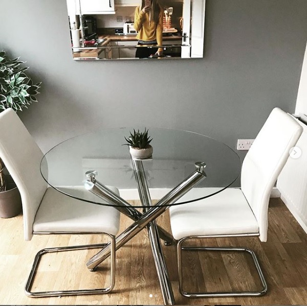 A glass and chrome dining table making a dining room feel bigger
