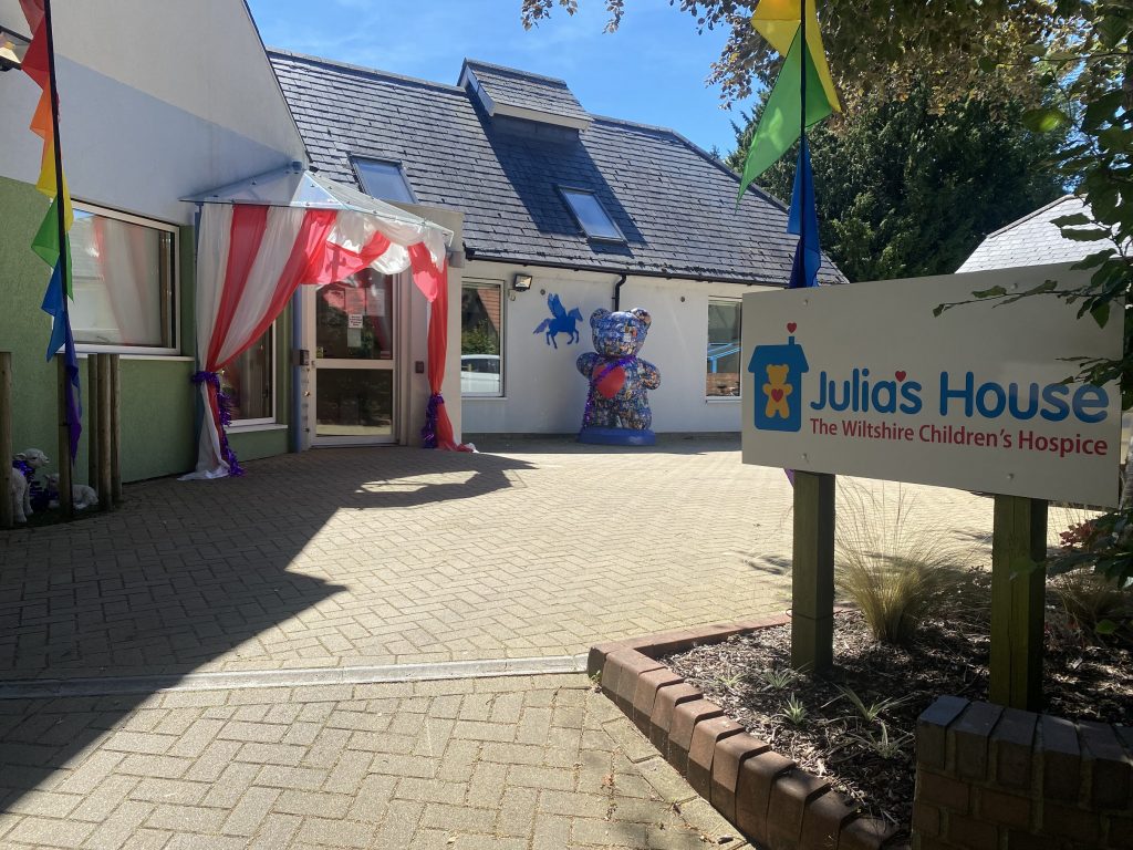 Julia's House Devizes Hospice entrance - bright courtyard with teddy statue and red/white circus tent over door