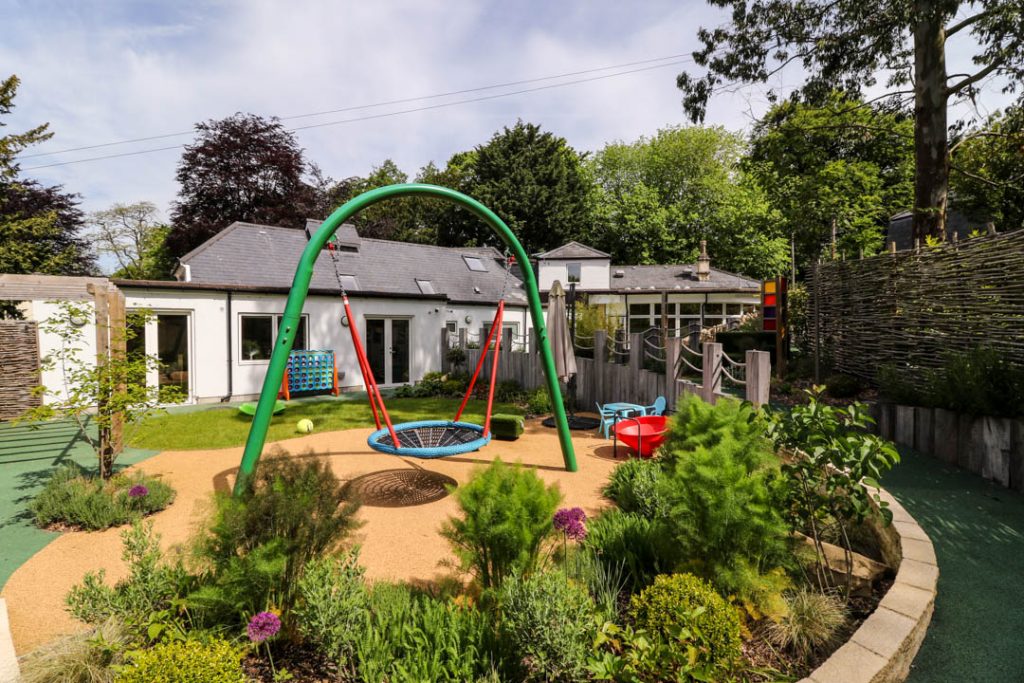 Julia's House garden - bright sunny garden area with accessible swing