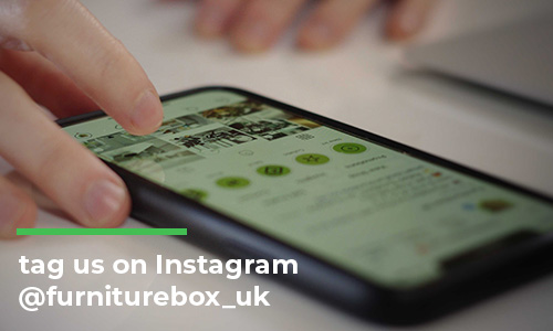 mobile phone on desk showing Furniturebox UK instagram page for essentials of good living room deisgn