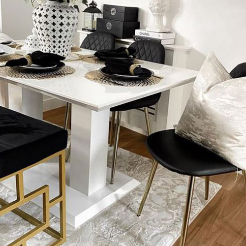 white gloss table and black chairs with gold legs. Accessories and valentines table decor is black, white and gold.
