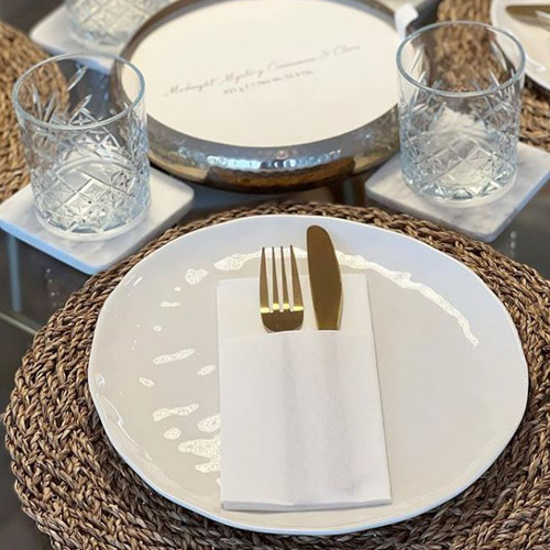 close up of table setting with white crockery and gold cutlery