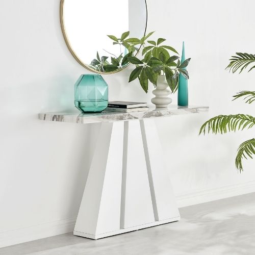 marble-effect console table with striking white tapered pillar legs beneath round gold framed wall mirror
