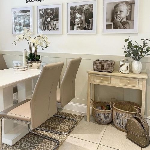 modern dining area with white high-gloss dining table and 4 faux leather chairs with cantilever legs, and rustic cream console table to one side, with 2 wicker storage baskets underneath. 