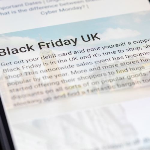 phone screen showing text that reads 'Black Friday UK - get out your debit card and pour yourself a cuppa. Black Friday is in the UK and it's time to shop...' fade to blur at bottom.
