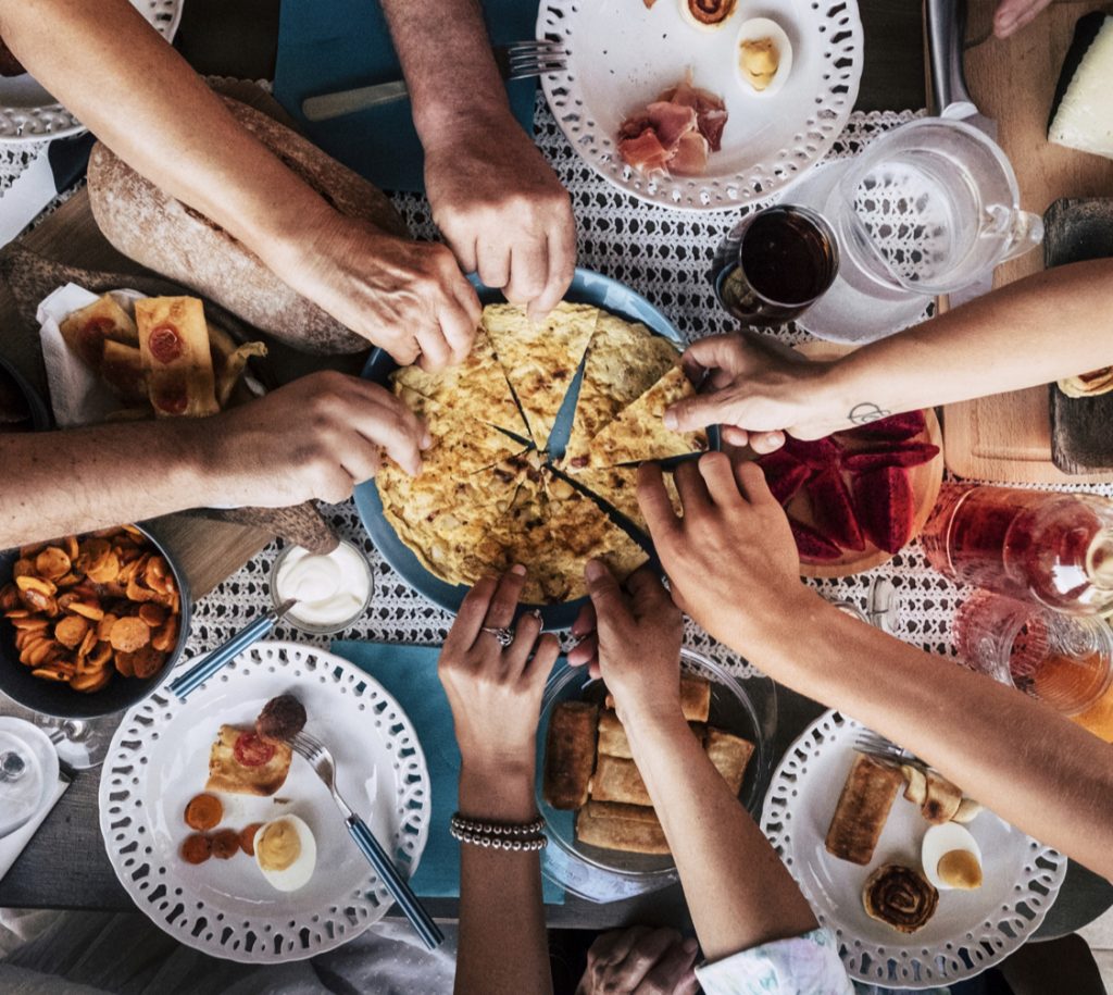 A dinner party leaning in to share food