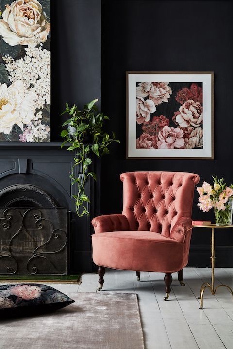 A textured pink armchair next to a fireplace