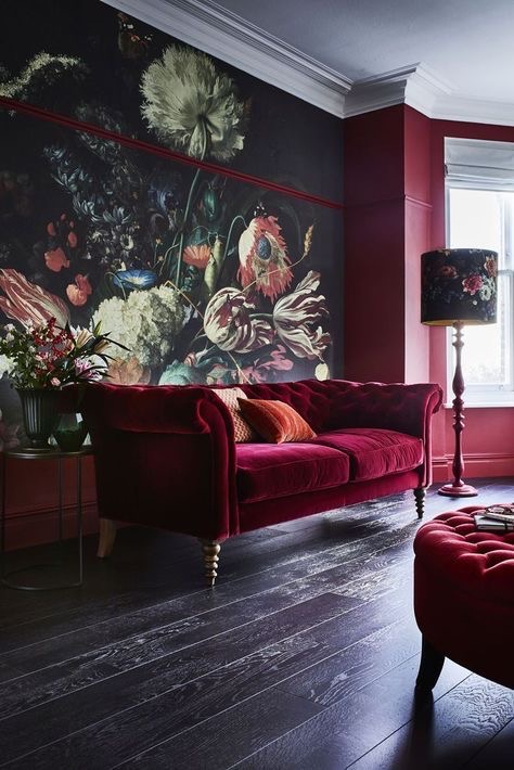 A luxury red velvet sofa with a large classy painting in the background