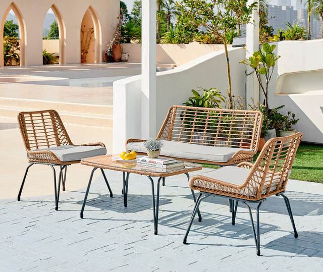 brown rattan outdoor sofa chairs and table set with black hairpin legs in bright patio area