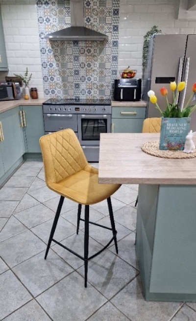 colourful kitchen diner with bar table kitchen island and yellow velvet bar stools acting as room divider