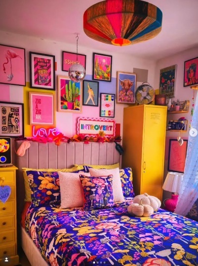 a bold and maximalist bedroom styling with fabric bed dressed in bold patterened duvet set, and with colourful gallery wall artwork behind