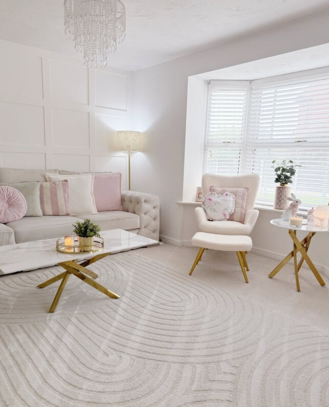 modern Bridgerton Regencycore living room with white marble and gold tales, chesterfield sofa, modern chandelier and bay window