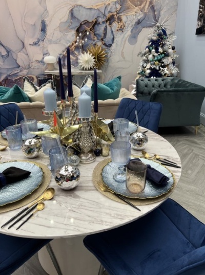 round marble effect diing table decorated with stars and celestial inspired Christmas table decor