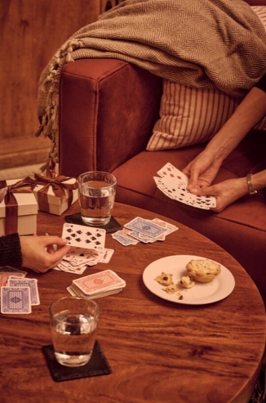 round wood coffee table with people playing cards