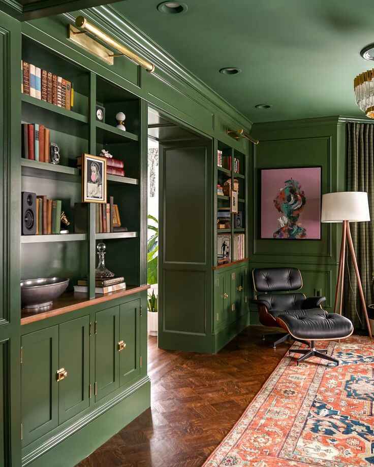 green colour drenched dining room with built in bookcase and mid century modern furniture