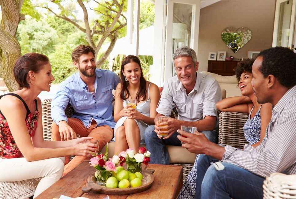 group of people sitting on conservatory funriture laughing and talking