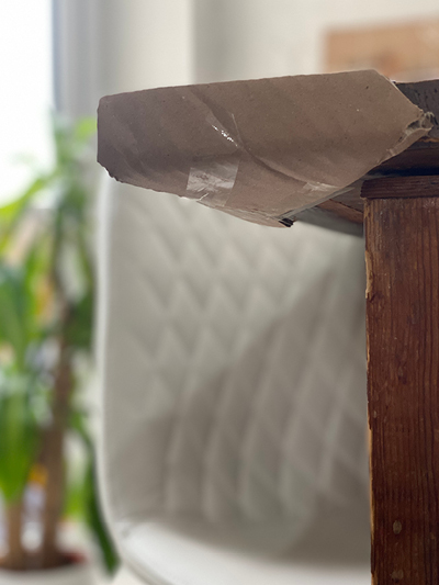 corner of wooden dining table wrapped in cardboard strip