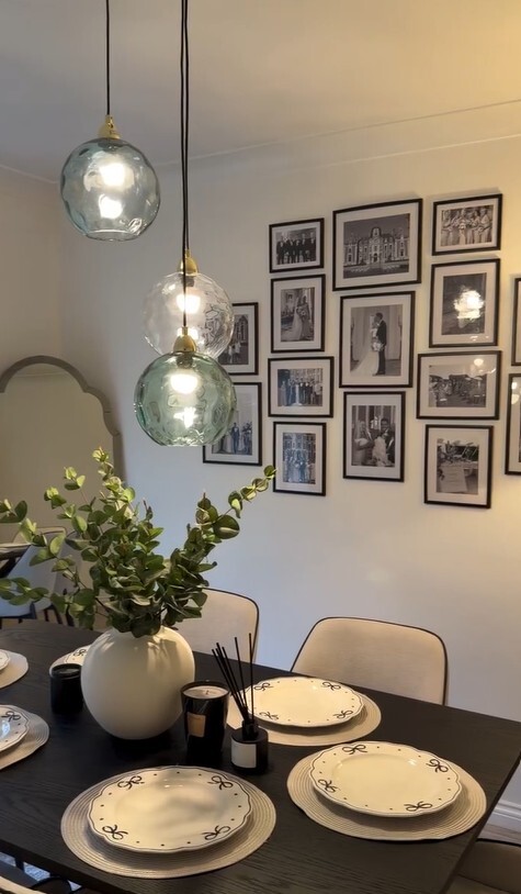 modern dining room with green and blue 3-globe glass pendant ceiling light above black wood dining table