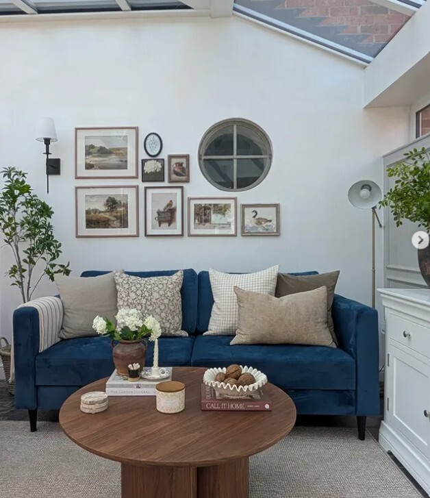 blue velvet sofa dressed with rustic textured cushions in neutral shades