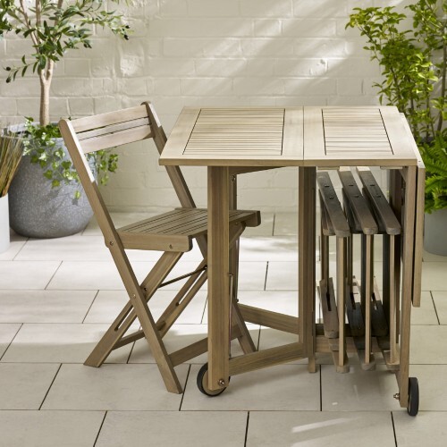 folding wooden garding table and chairs against a wall
