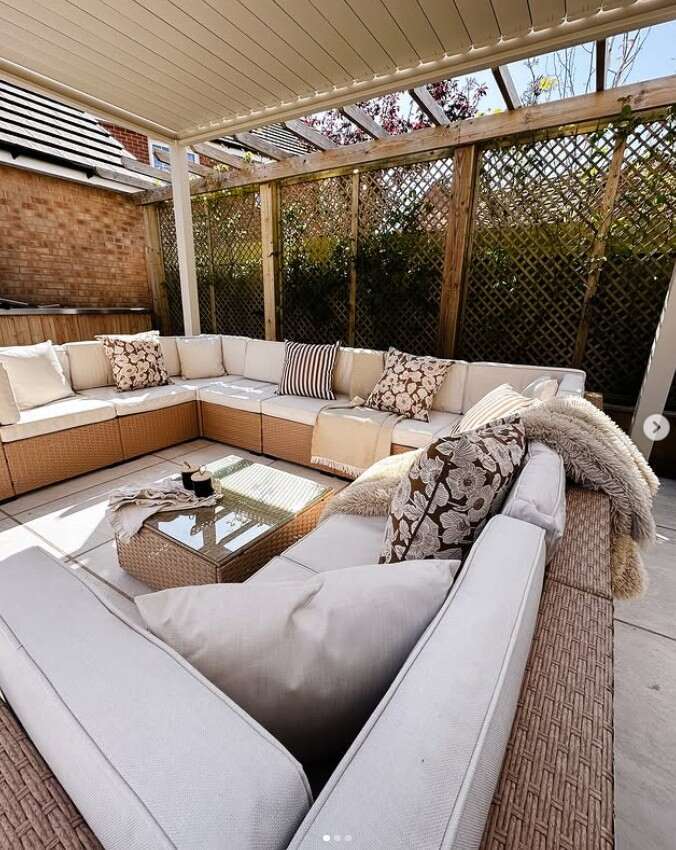 beige rattan modular garden sofa with cream cushions in U shade arrangement under garden pergoda