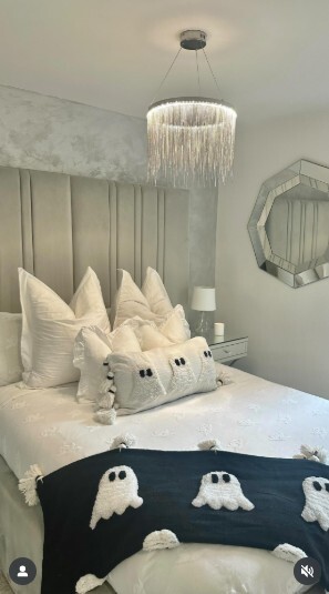 modern grey and silver bedroom with grey velvet bed, decorated with halloween decor pillows and throws