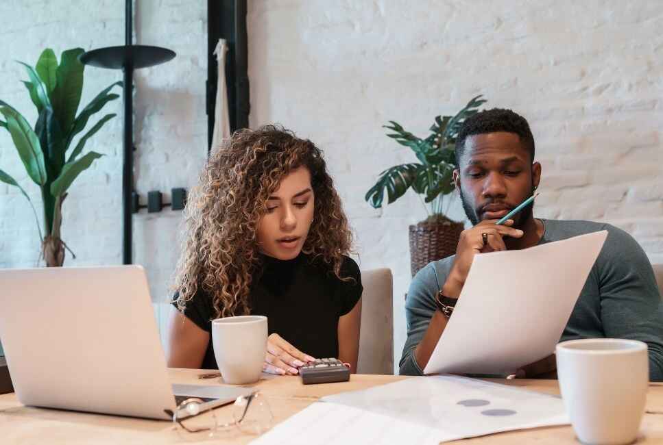 couple in modern living space look over paperwork and finances