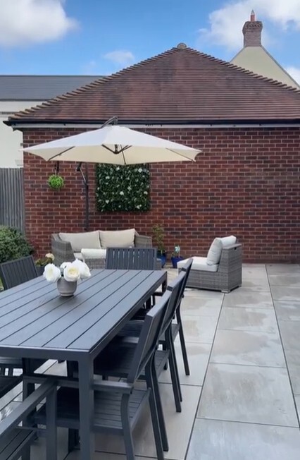 grey rattan garden sofa and grey metal outdoor dining table
