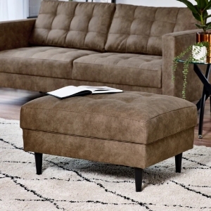 upholstered brown faux leather footstool used as coffee table in front of matching armchair in modern living room