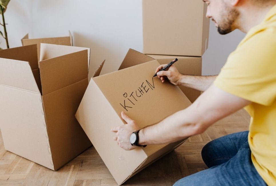 moving hosue packing safely - cardboard box with written label 'kitchen'