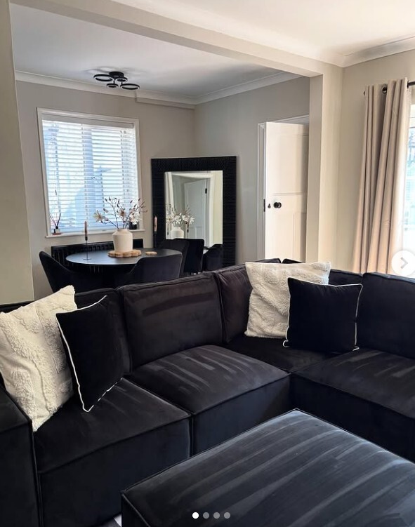 open plan living room and dining space with round glass dining table and black sofa
