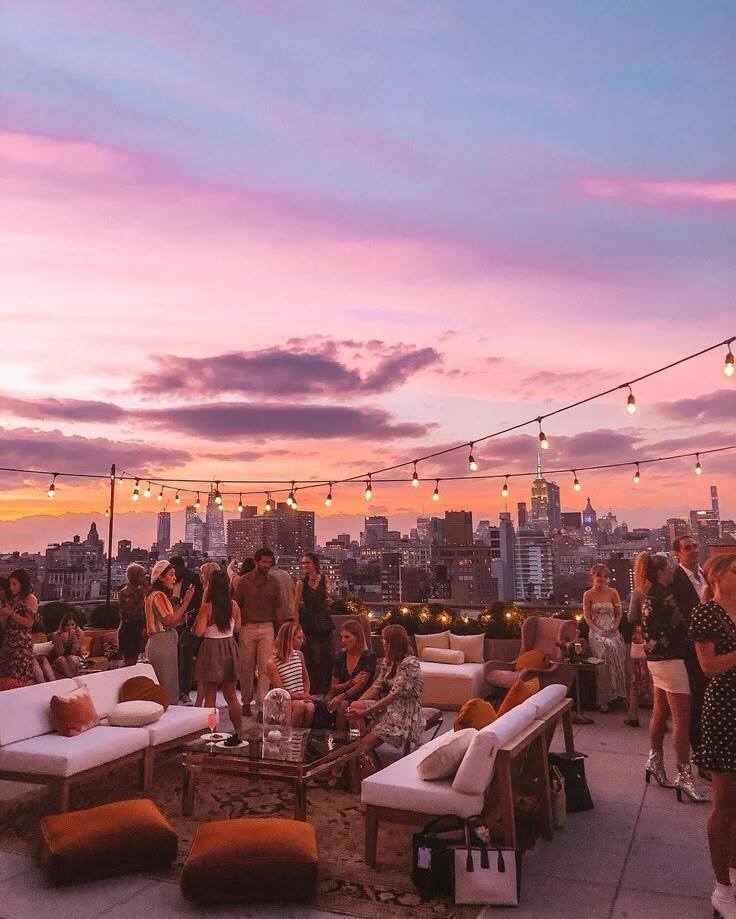 rooftop terrace party with city skyline at sunset