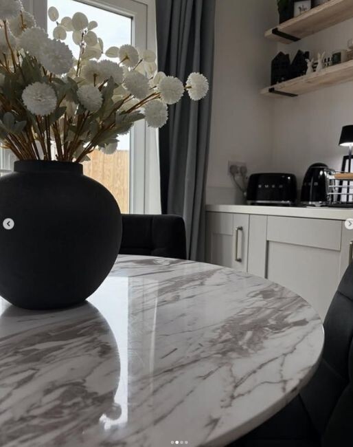 round marble dining table with balck velvet dining chairs in modern kitchen dining space