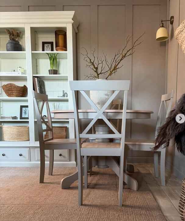 pretty round wood dining table in paneled dining space with warm neutral decor 