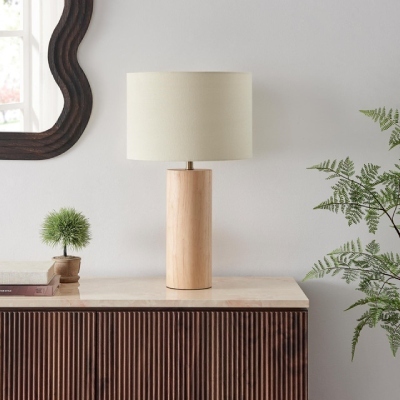 Scandi style table lamp with cylindrical wood base and round cream fabric shade on a marble top sideboard