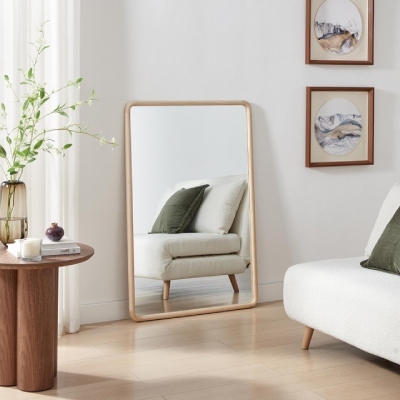 pale oak wood frame wall mirror on floor of light Scandi living room