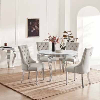 round marble effect dining table with silver steel legs in Rococo style, with 4 grey velvet knockerback dining chairs, in bright dining room space