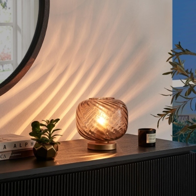 small orange and brass glass accent lamp for dining room on black sideboard