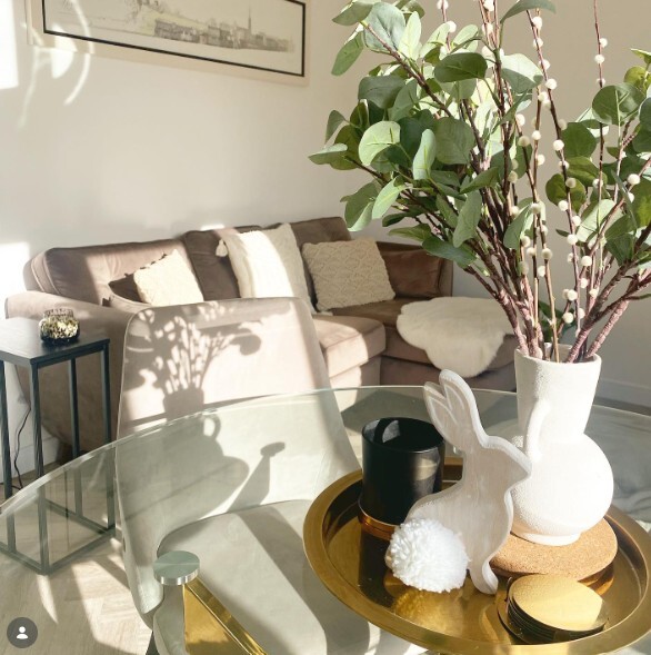 small open plan living room and dining space with round glasds dining table and grey sofa