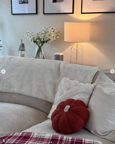 cosy living room with grey sofa dressed in autumnal coloured cushions with pumpkin pillow