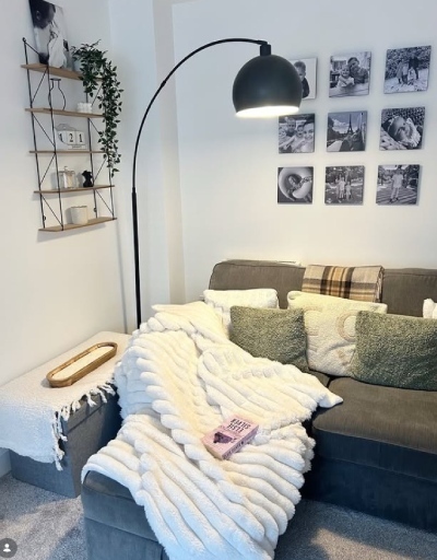a modern living room with grey sofa dressed with textured throws and cushions and with arc standing floor lamp